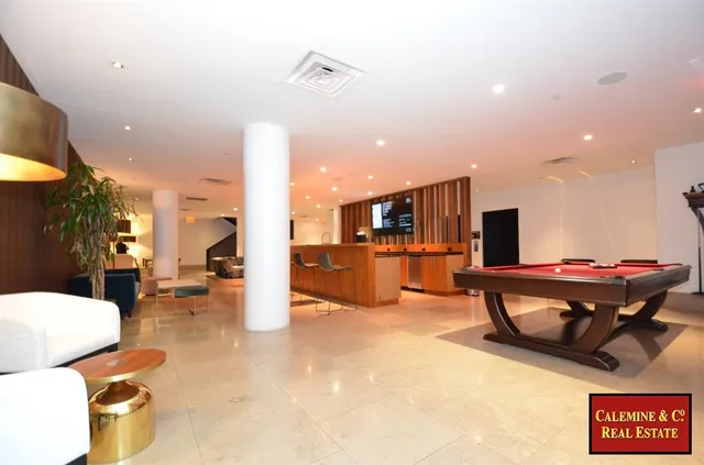 a kitchen view with stainless steel appliances wooden floor and living room view