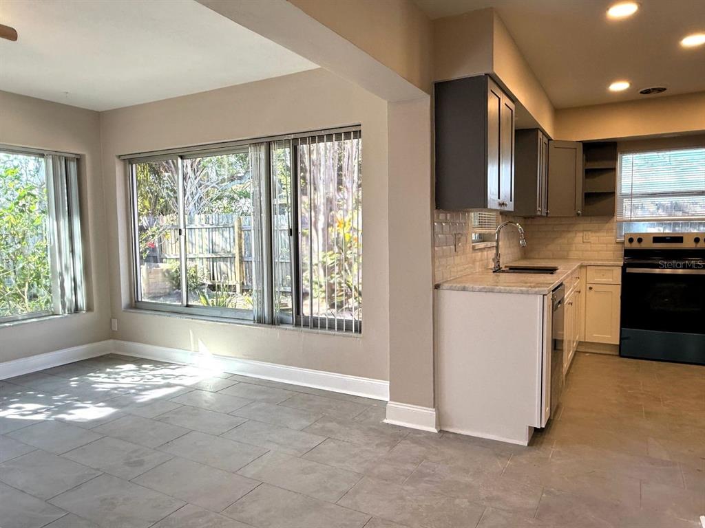 2489 Del Rio Way Dunedin, FL 34698 - Photo 11 of 24 a kitchen with stainless steel appliances granite countertop a stove a sink and a refrigerator