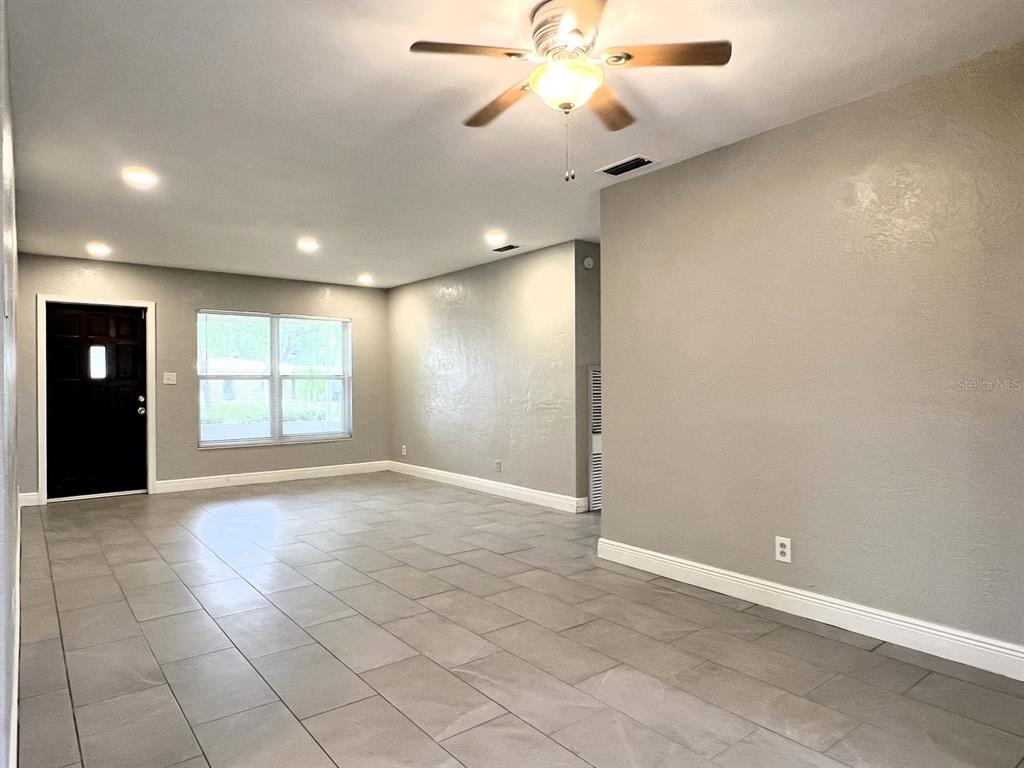 2489 Del Rio Way Dunedin, FL 34698 - Photo 4 of 24 an empty room with windows and fan
