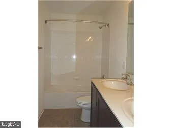 a bathroom with a granite countertop sink a toilet and a shower