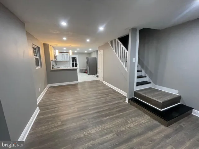 a view of a hallway with stairs and wooden floor