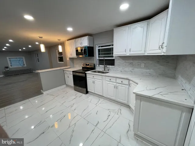 a kitchen with white cabinets stainless steel appliances and sink