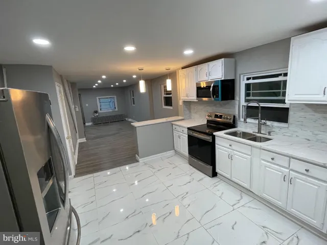 a kitchen with stainless steel appliances a refrigerator sink and microwave