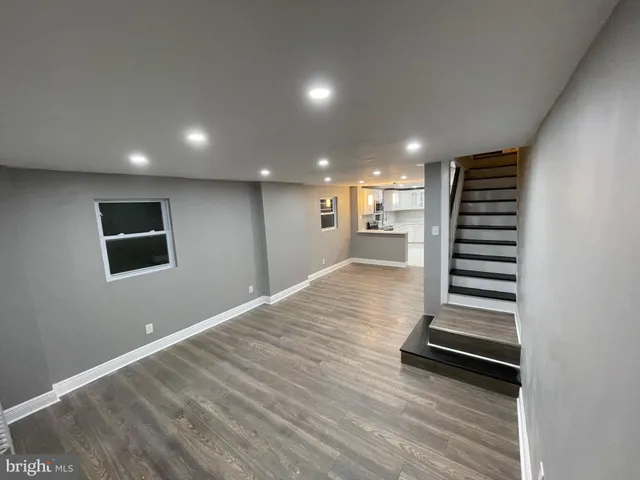 a view of a livingroom with wooden floor and stairs
