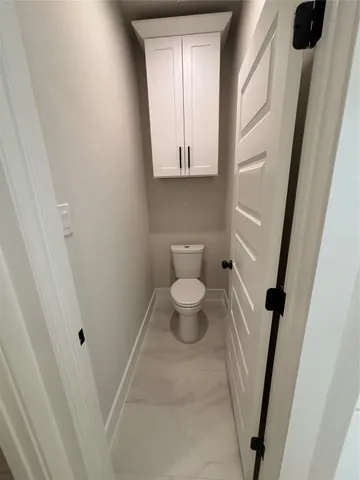a bathroom with a toilet and a mirror