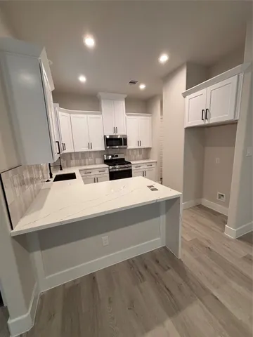 a kitchen with kitchen island sink stove and cabinets