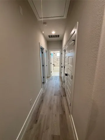 a view of a hallway with wooden floor