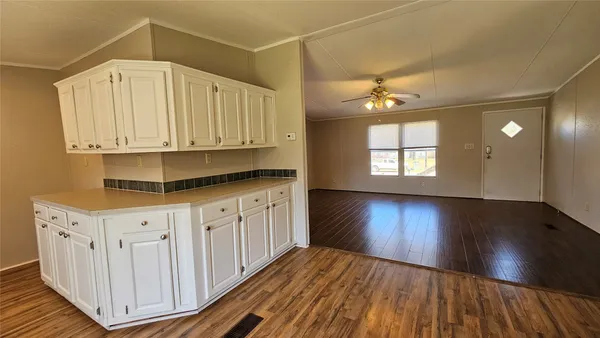 a kitchen with wooden floors and white cabinets