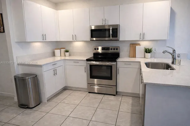 a kitchen with a sink stove and white cabinets
