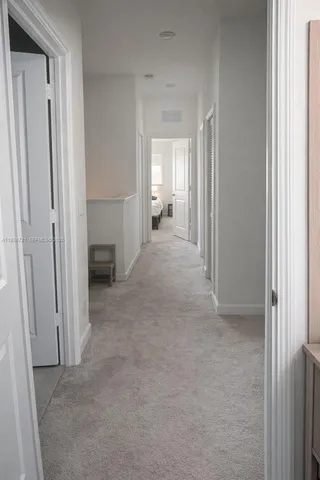 a view of a hallway with a livingroom and a bathroom