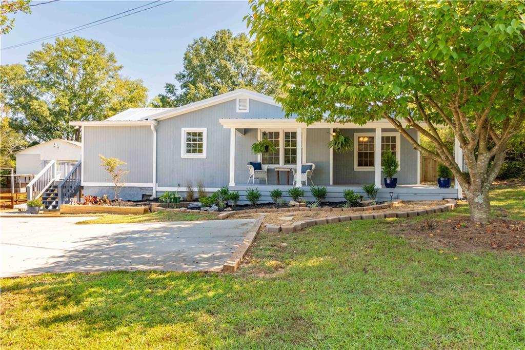a front view of house with yard and trees around