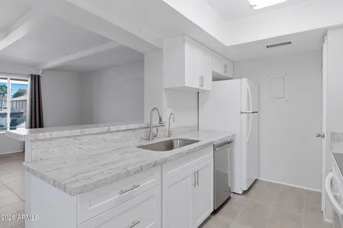 a kitchen with granite countertop white cabinets and white appliances