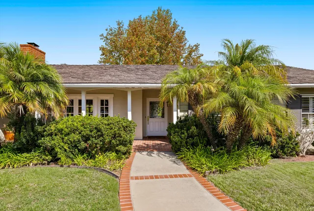 a front view of a house with a garden