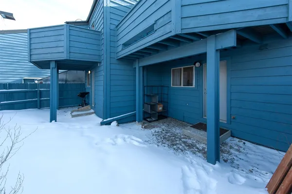 a view of a house with a yard covered in snow