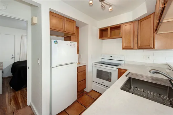 a kitchen with a refrigerator and a stove top oven