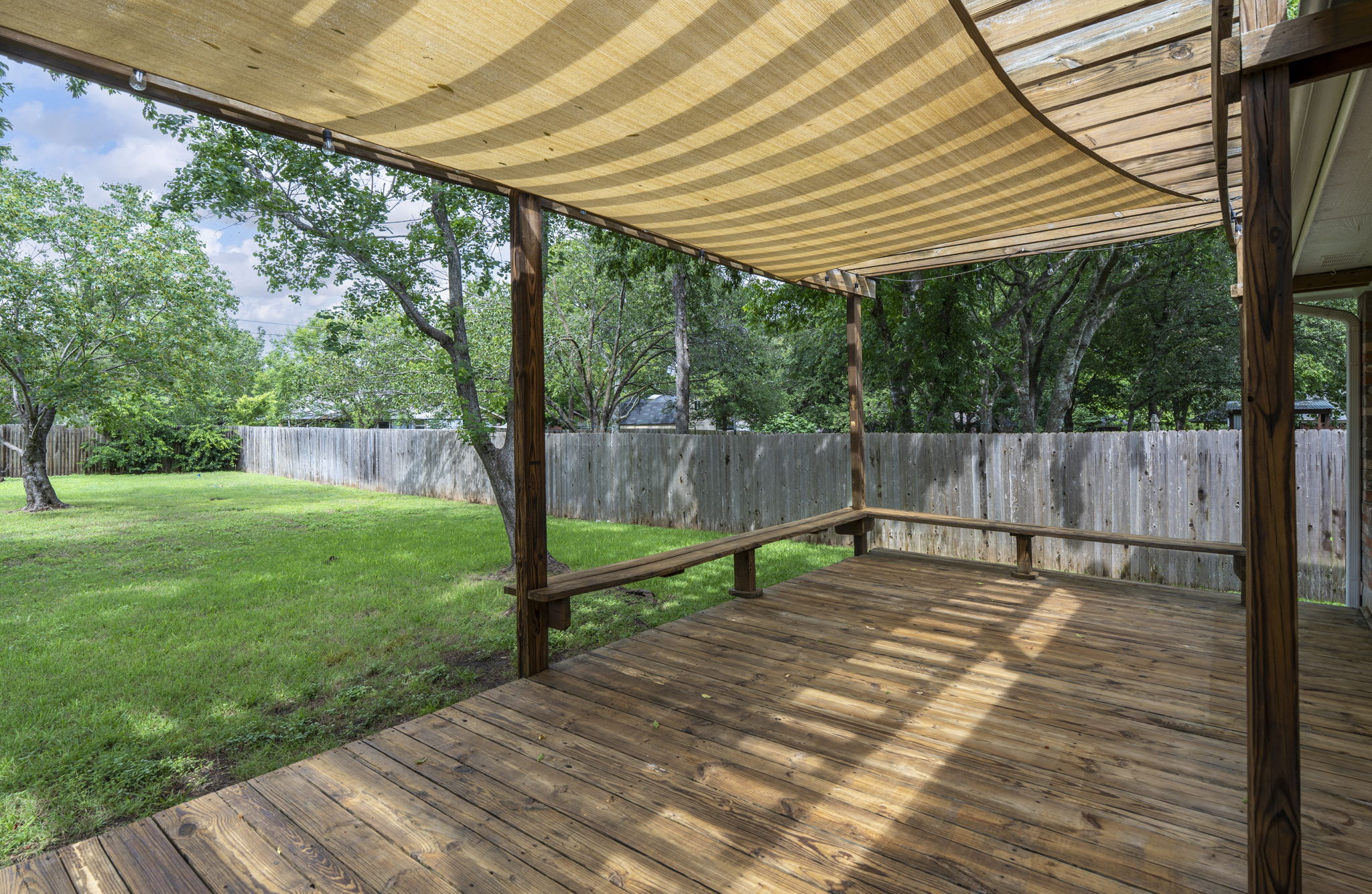 7172 Ridge Oak Road Austin, TX 78749 - Photo 6 of 40 A spacious wooden deck with a slatted shade cover provides an inviting outdoor retreat.