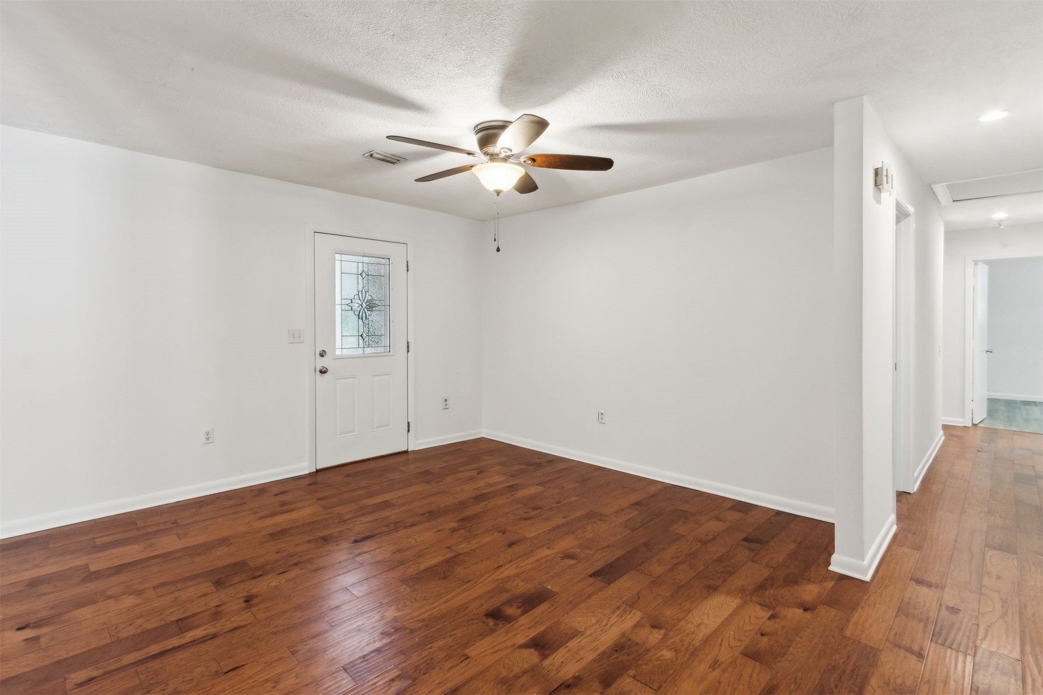 2441 Amelia Road Fernandina Beach, FL 32034 - Photo 12 of 36 an empty room with wooden floor fan and windows