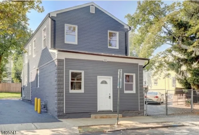 a front view of a house with a tree