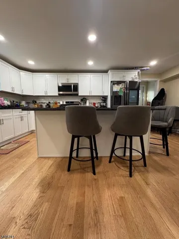 a view of kitchen with dining table chairs sink and wooden floor