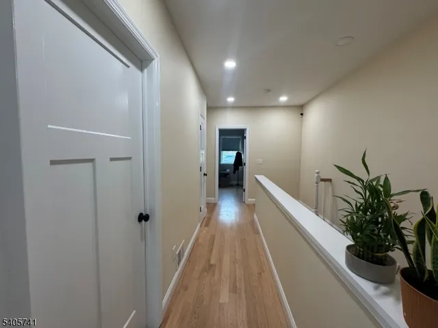 a view of a hallway with wooden floor and a potted plant