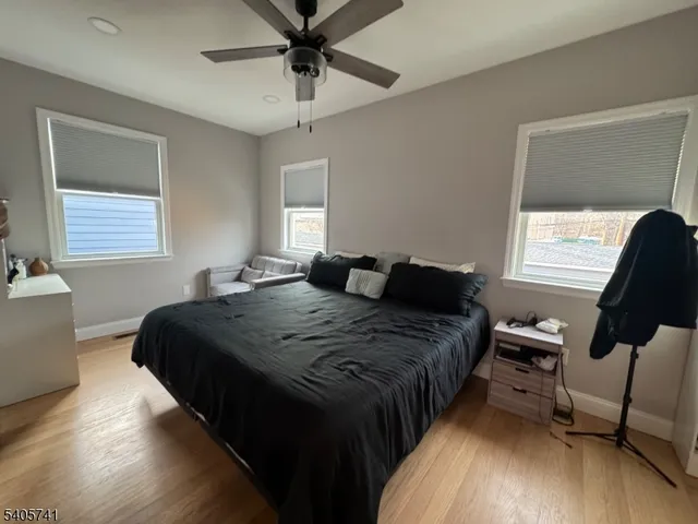 a bedroom with bed window and mirror