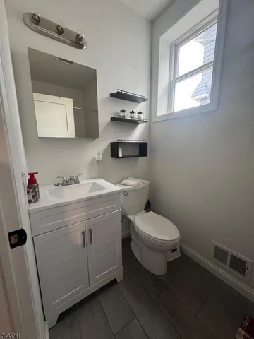 a bathroom with a toilet sink and mirror