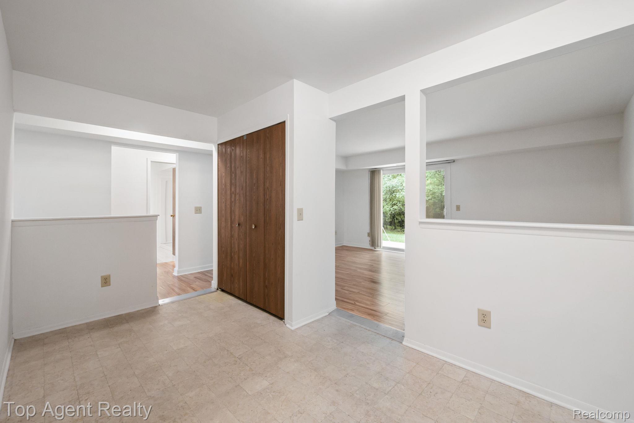 23420 Middlebelt Road Farmington, MI 48336 - Photo 10 of 32 Neutral interior with wood-finish flooring, half-wall openings, and a sliding glass door