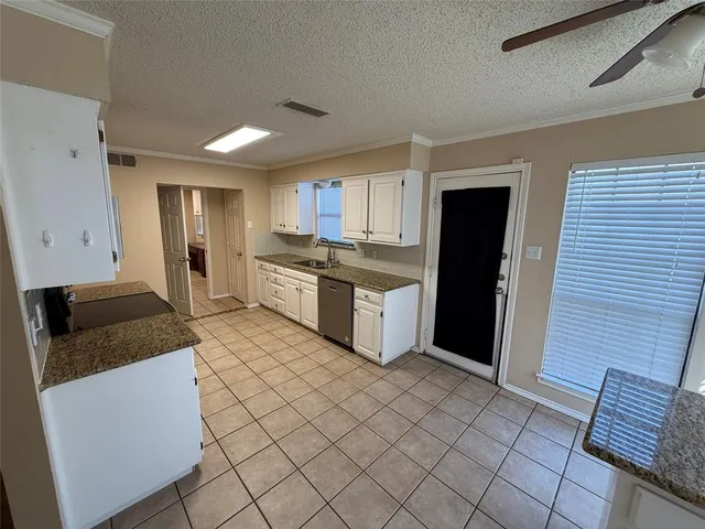 a kitchen with granite countertop a refrigerator and a stove top oven