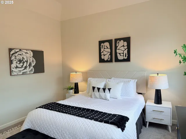 a bedroom with a bed and painting on the wall