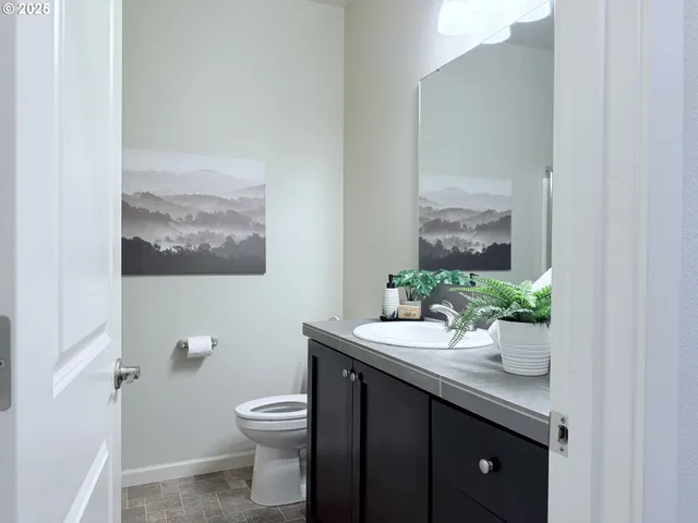 a bathroom with a granite countertop sink a toilet and a mirror