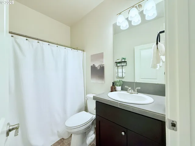 a bathroom with a sink vanity mirror and toilet