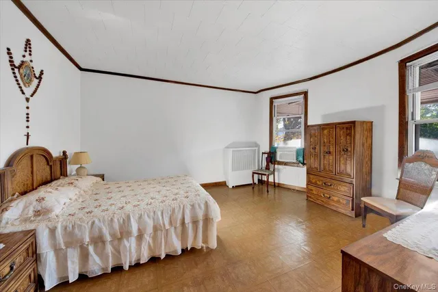 a bedroom with a bed and a chair with the wooden floor