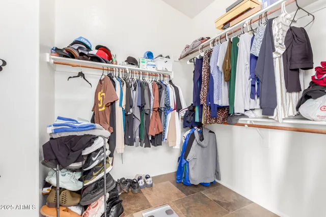 a view of walk in closet with clothes and shoes