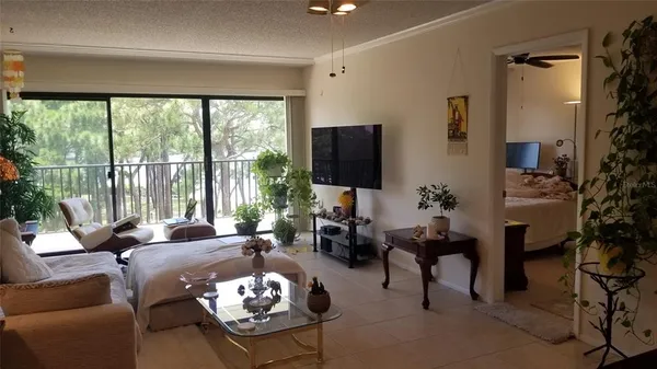 a living room with furniture a large window and a flat screen tv