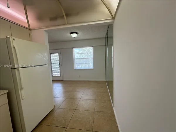 a view of a kitchen with a refrigerator and a window