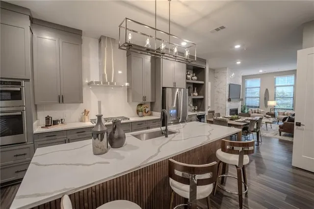 a kitchen with sink a refrigerator and chairs