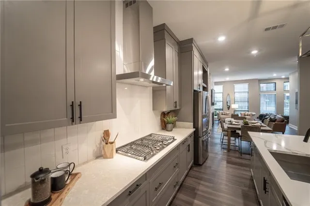 a kitchen with stainless steel appliances granite countertop a lot of counter space and wooden floors