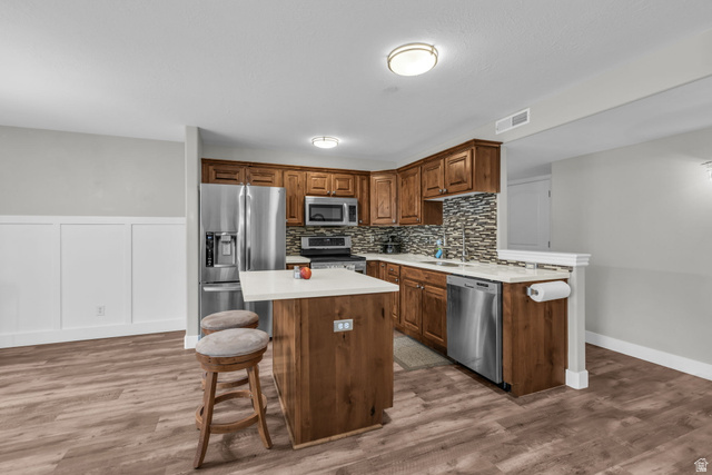 905 South Main Street, Unit G Layton, UT 84041 - Photo 3 of 36 Kitchen featuring appliances with stainless steel finishes, a kitchen bar, light wood-style flooring, and a center island
