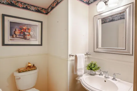 a bathroom with a toilet a sink and mirror