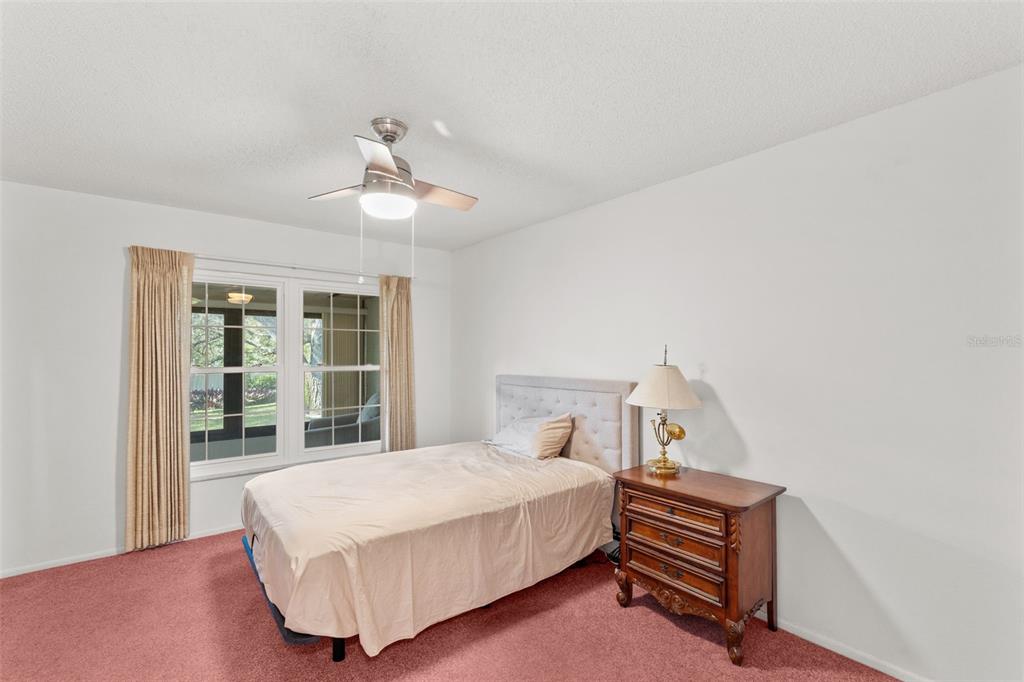 1114 Castlemay Circle Dunedin, FL 34698 - Photo 13 of 21 a bedroom with a bed wooden floor and window