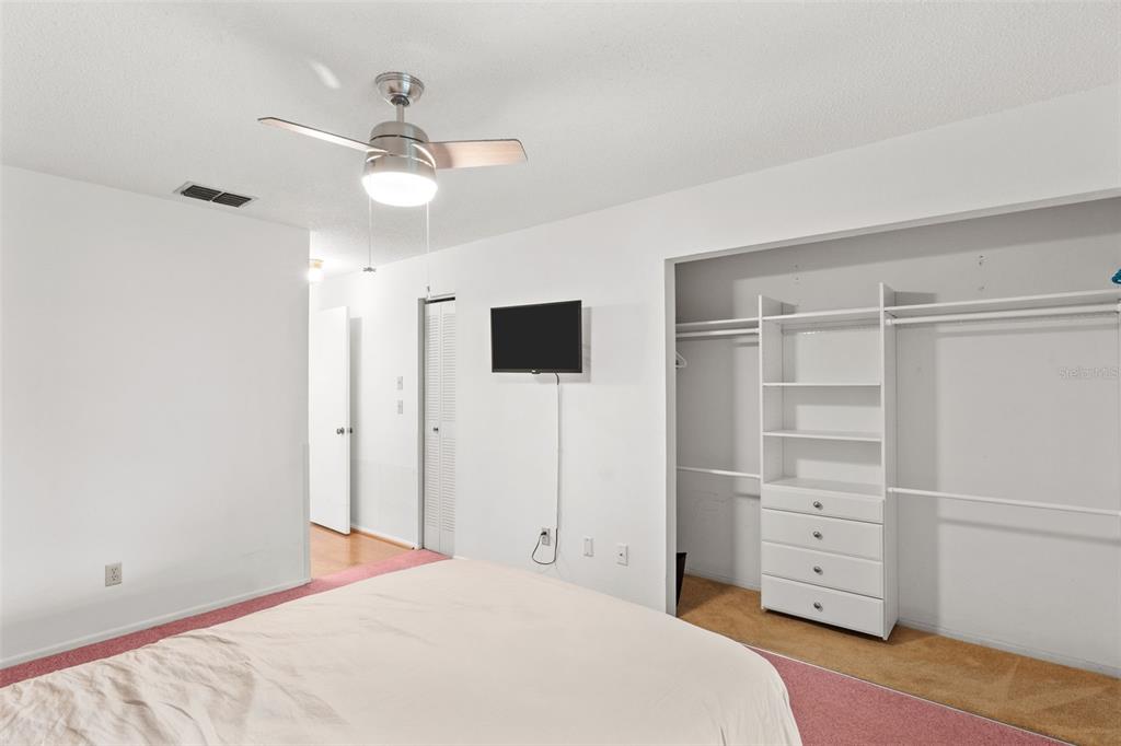 1114 Castlemay Circle Dunedin, FL 34698 - Photo 15 of 21 a bedroom with a bed and a flat tv screen on dresser