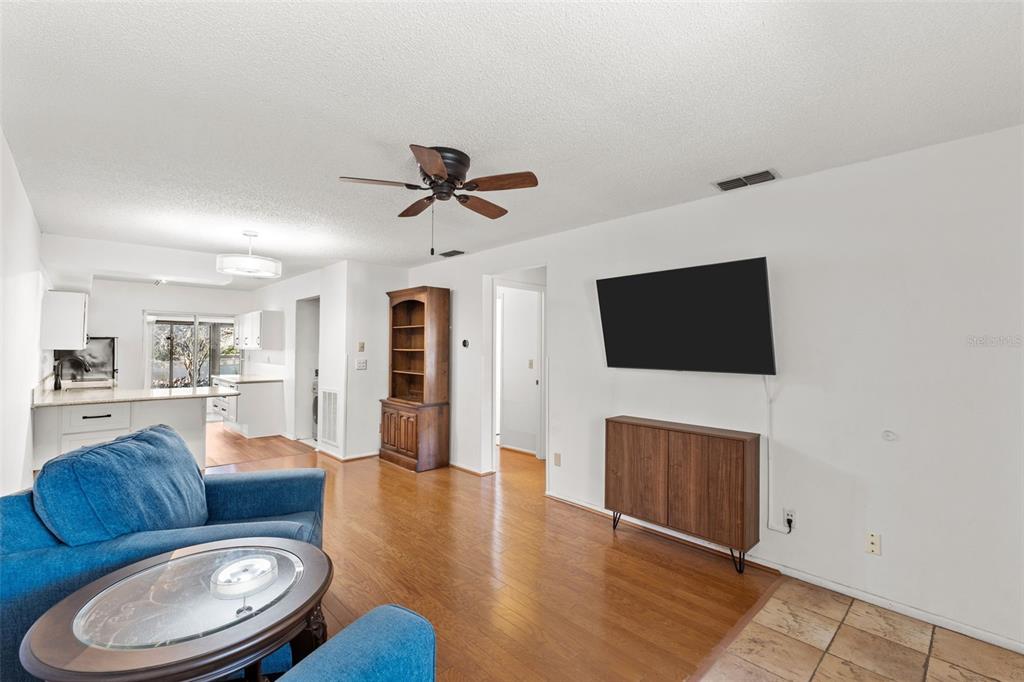 1114 Castlemay Circle Dunedin, FL 34698 - Photo 3 of 21 a living room with furniture a flat screen tv and a fireplace