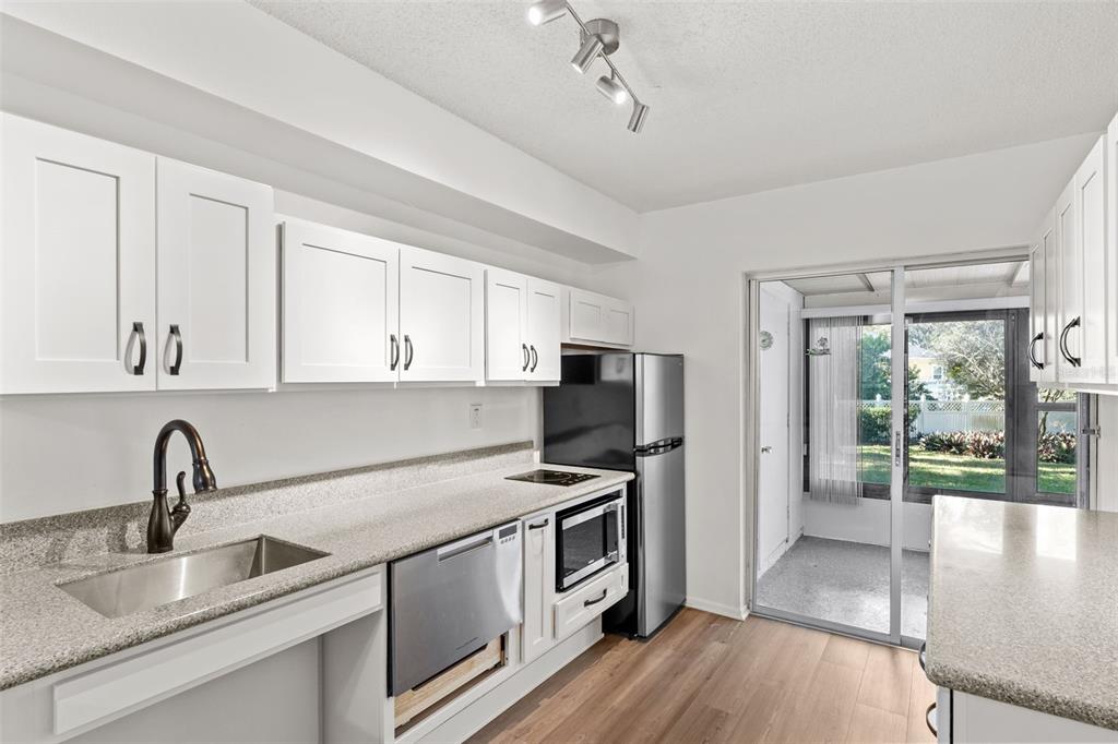 1114 Castlemay Circle Dunedin, FL 34698 - Photo 7 of 21 a kitchen that has a sink stainless steel appliances a counter space and a window