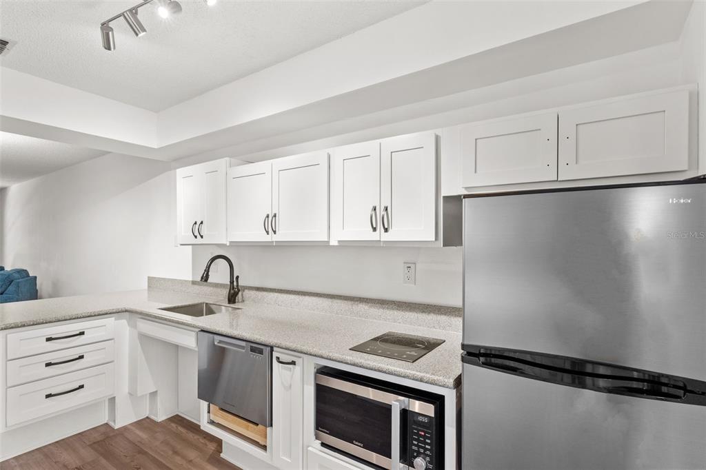 1114 Castlemay Circle Dunedin, FL 34698 - Photo 8 of 21 a kitchen with kitchen island a sink and white cabinets