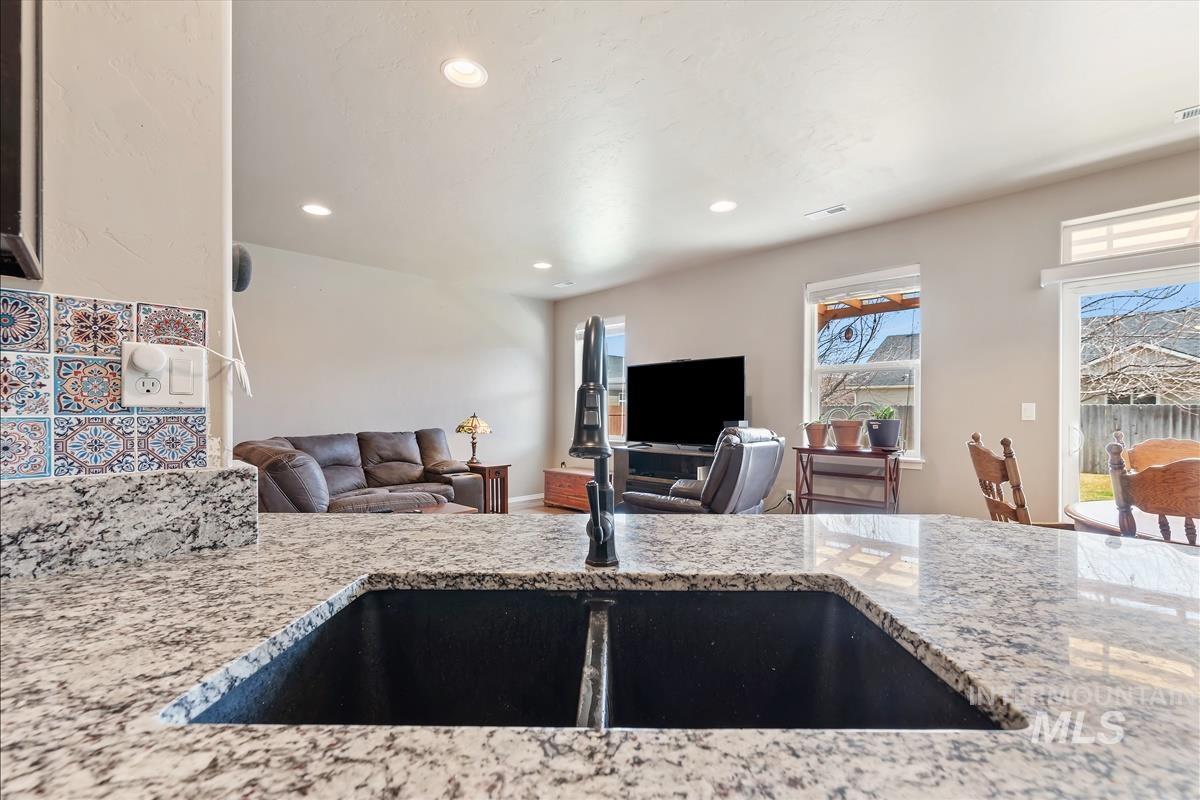 6308 South Kelso Way Boise, ID 83709 - Photo 35 of 35 Kitchen featuring open floor plan, light stone counters, and recessed lighting