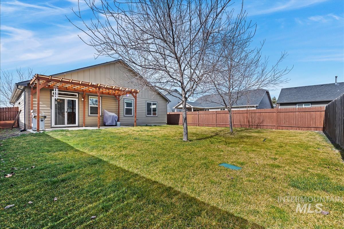 6308 South Kelso Way Boise, ID 83709 - Photo 26 of 35 Back of property featuring board and batten siding, a patio, a fenced backyard, and a pergola