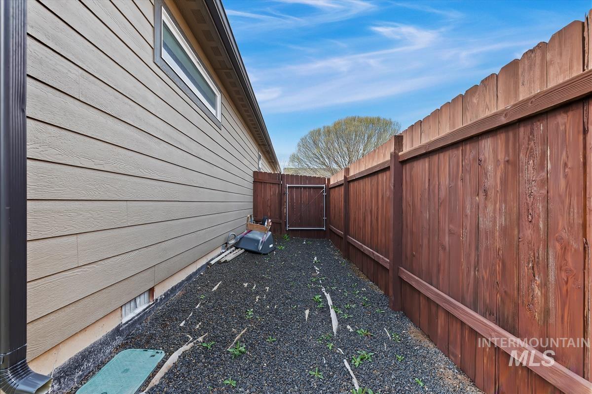 6308 South Kelso Way Boise, ID 83709 - Photo 29 of 35 View of home's exterior featuring a fenced backyard and a gate
