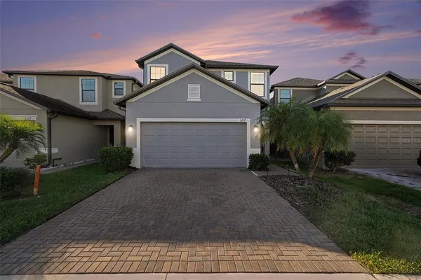 a front view of a house with a yard and garage