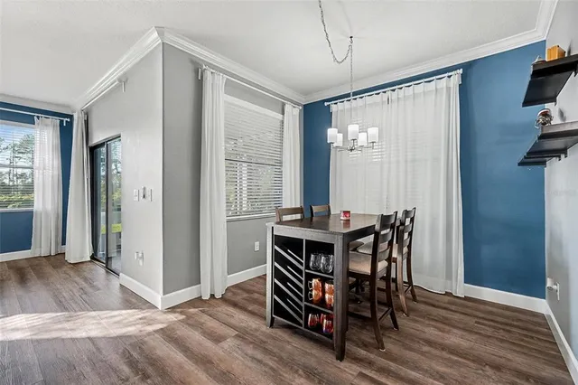 a view of a a dining room with furniture window and wooden floor