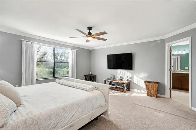 a spacious bedroom with a bed and a flat screen tv